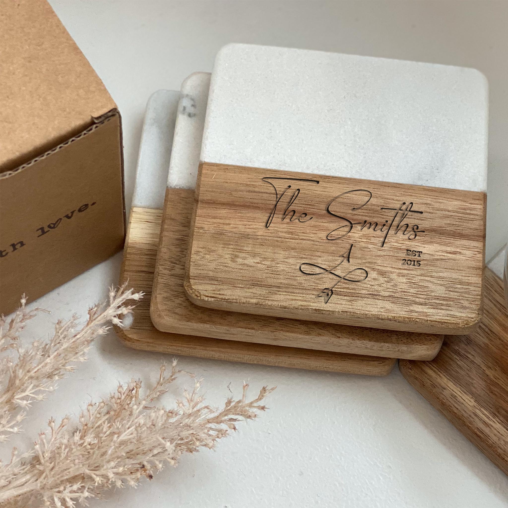 a stack of three square shaped wedding coasters with engraved text the smiths