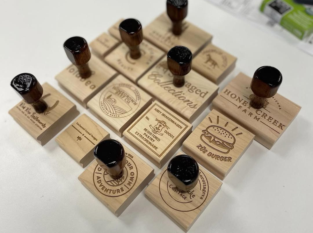 Collection of engraved wooden business logo stamps with dark wood handles