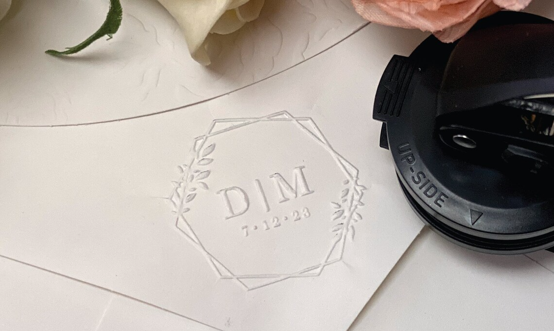 An embosser design features a custom engraving, with intricate details such company logo, monogram, or decorative pattern.