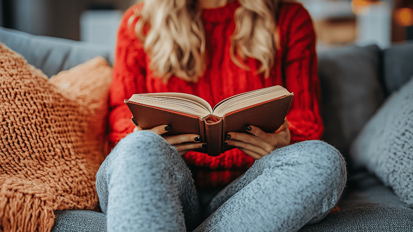 a woman reading a book on a couch