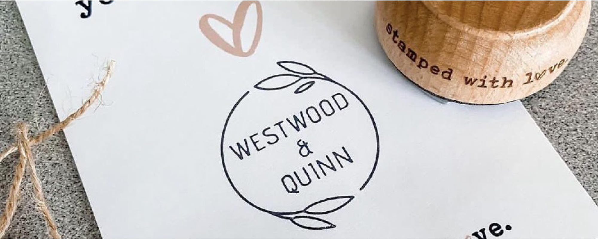 Westwood & Quinn logo imprinted with a custom rubber stamp on a card