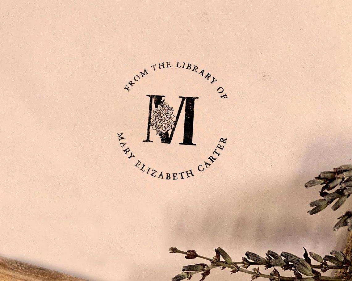 Custom ex libris stamp imprint From the Library of M Mary Elizabeth Carter with floral monogram on paper, accompanied by dried lavender