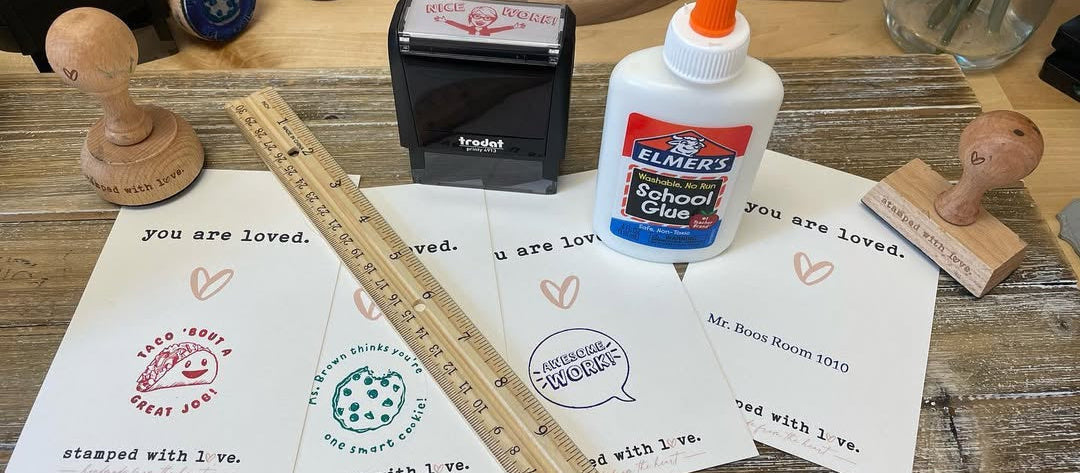 Assorted colorful teacher stamps with encouraging phrases and designs on printed cards