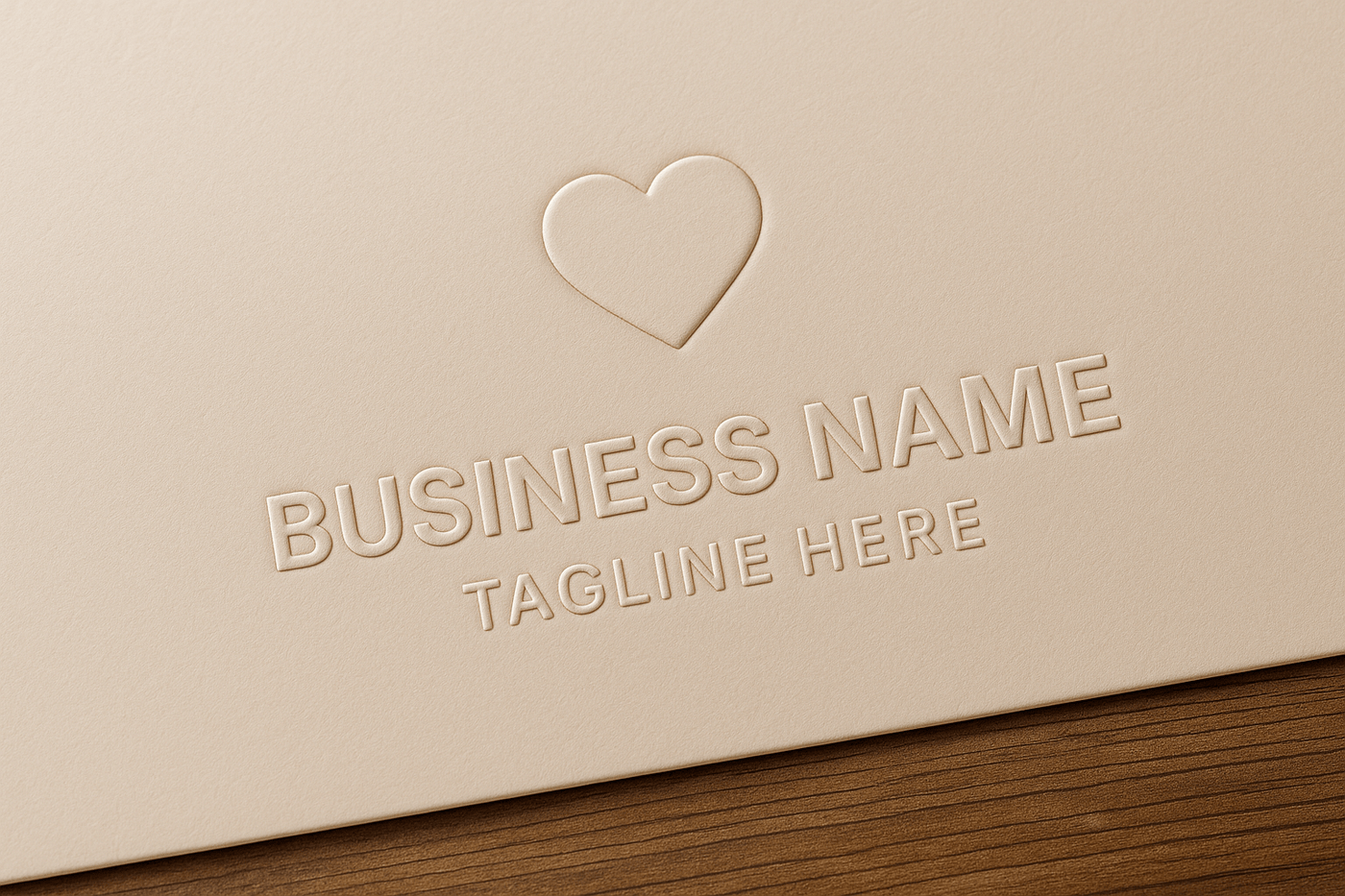 A close-up photograph of an embossed heart logo with placeholder business name and tagline on beige cardstock paper