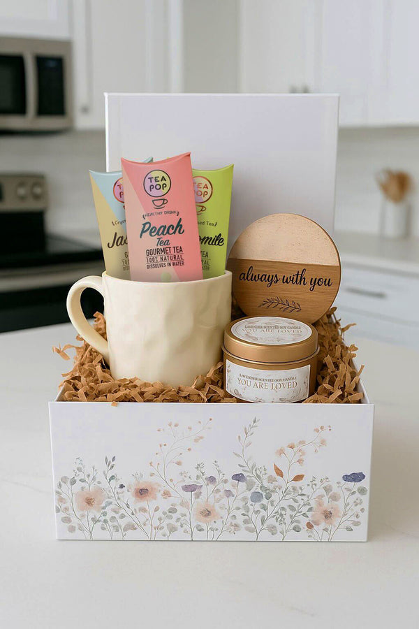 Get well soon care package with ceramic mug, lavender candle, inspirational coaster, and three gourmet tea sticks in a floral gift box.