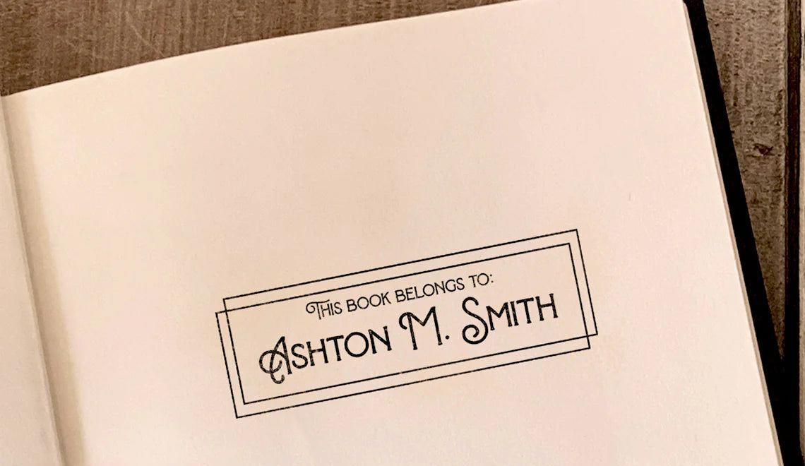 Personalized book ownership stamp with name Ashton M. Smith in art deco frame