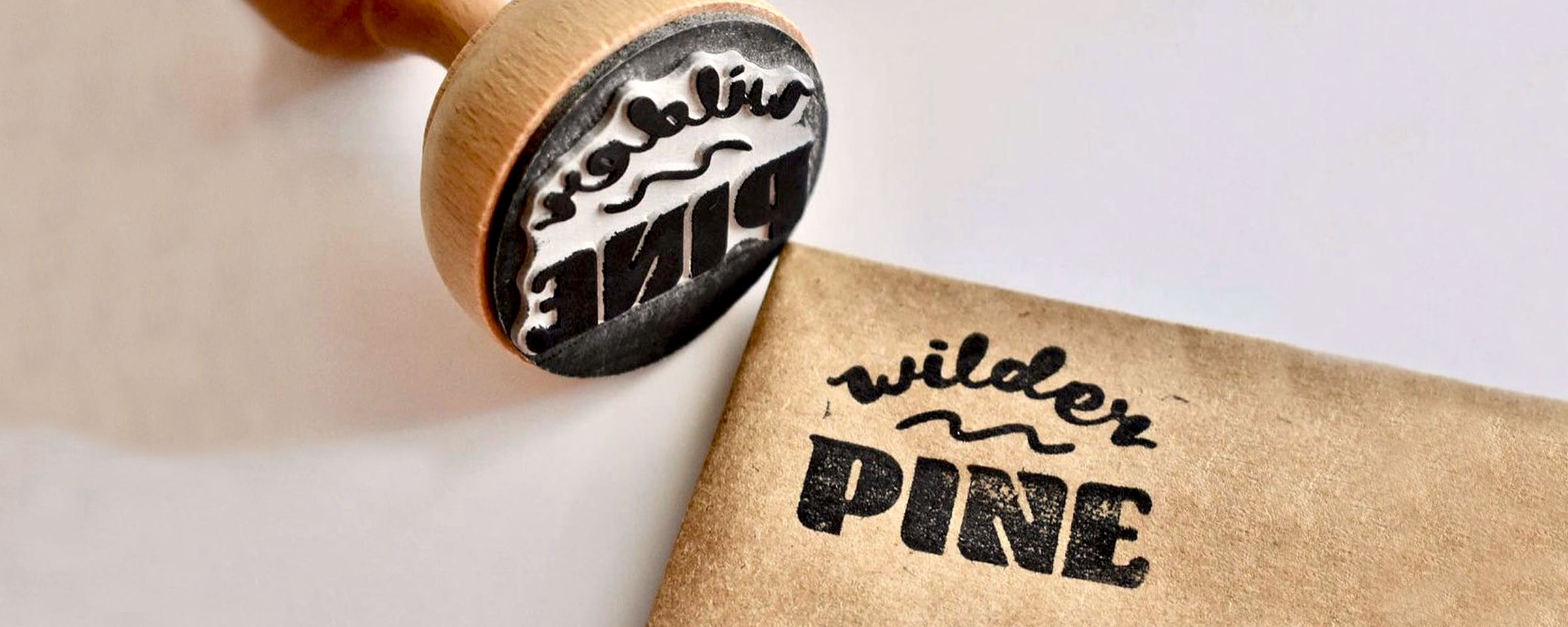 customized rubber stamp with Wilder Pine logo imprinted on a brown parchment paper