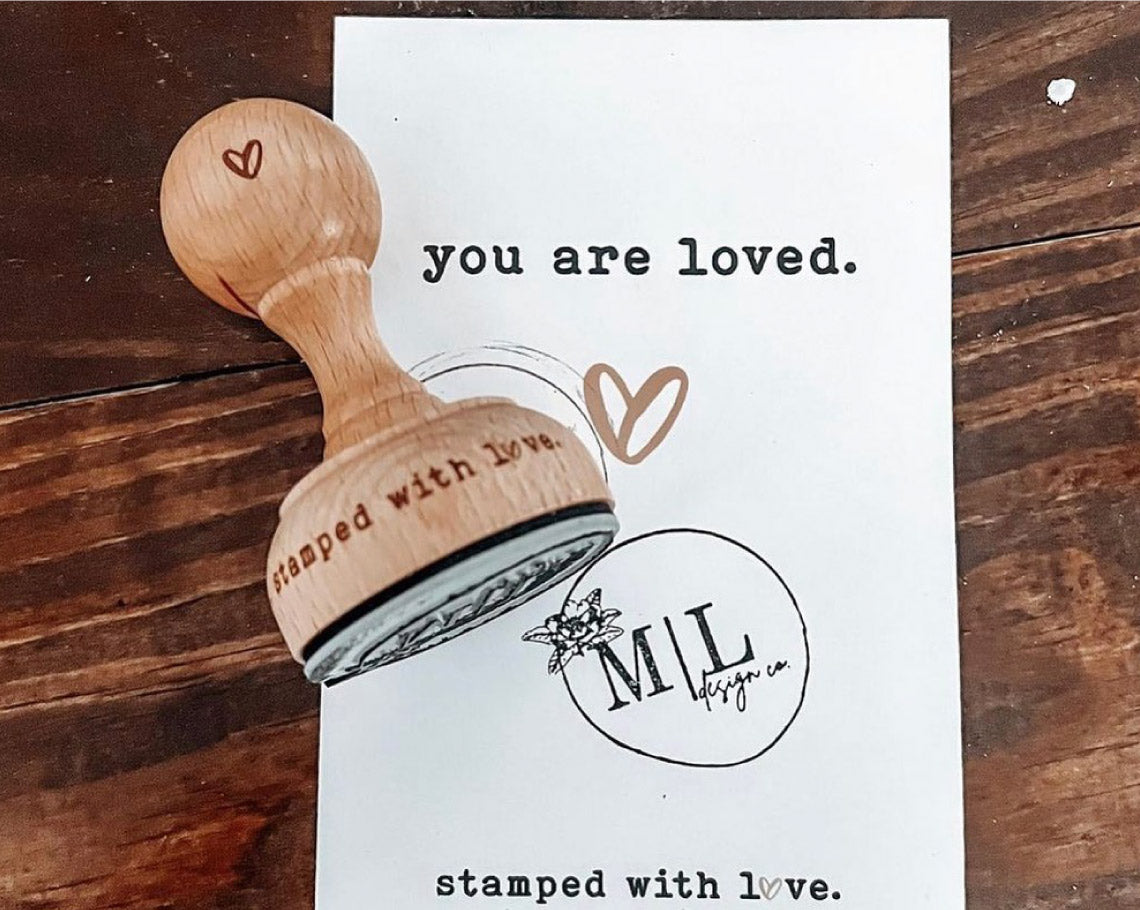 round rubber stamp with a custom circular logo imprinted on a card