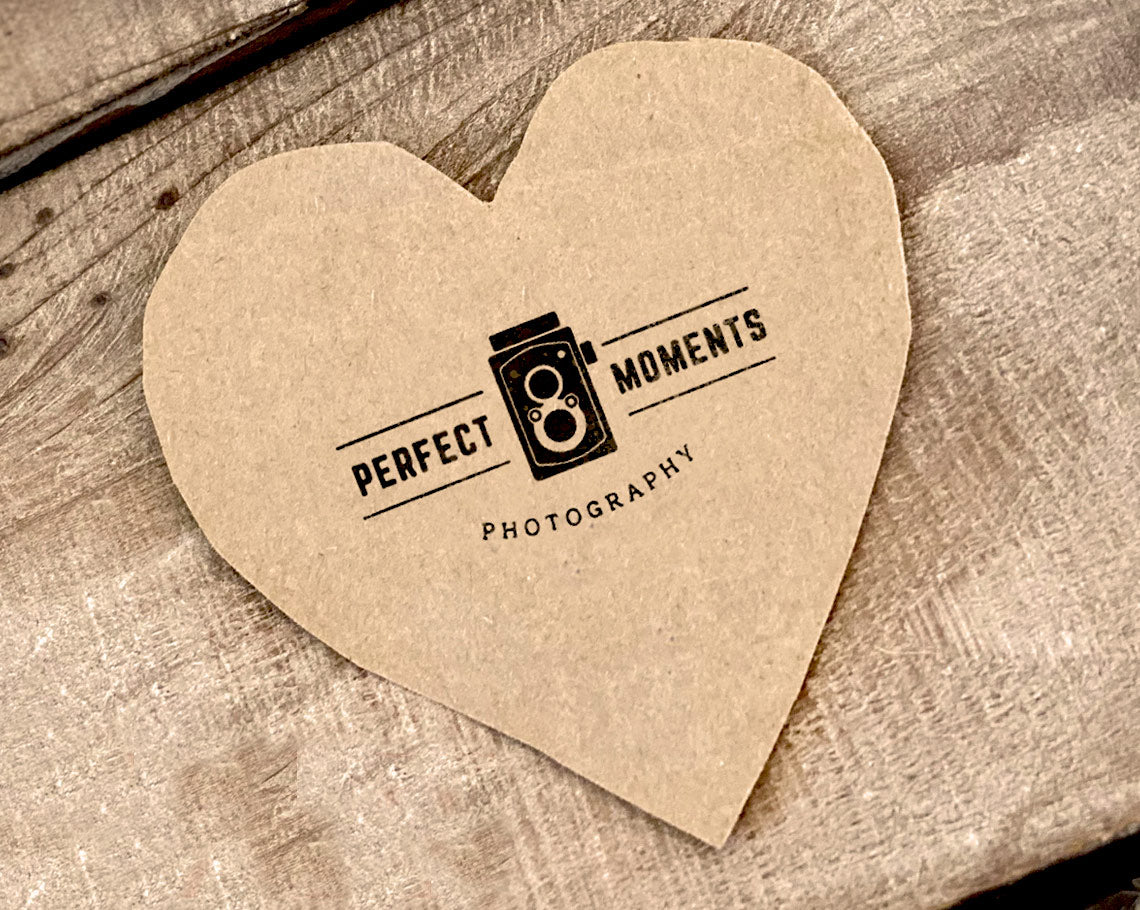 Perfect moments photography logo imprinted with rubber stamp on a heart shaped brown paper