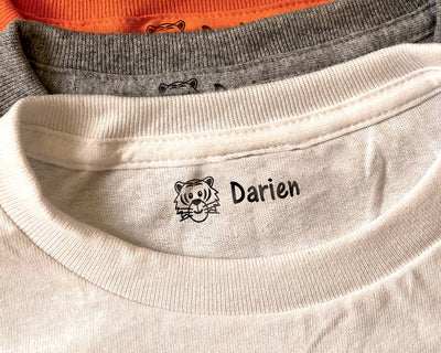 clothing stamp imprinted on the neck crease of a t shirt with a cartoon tiger face and kids name