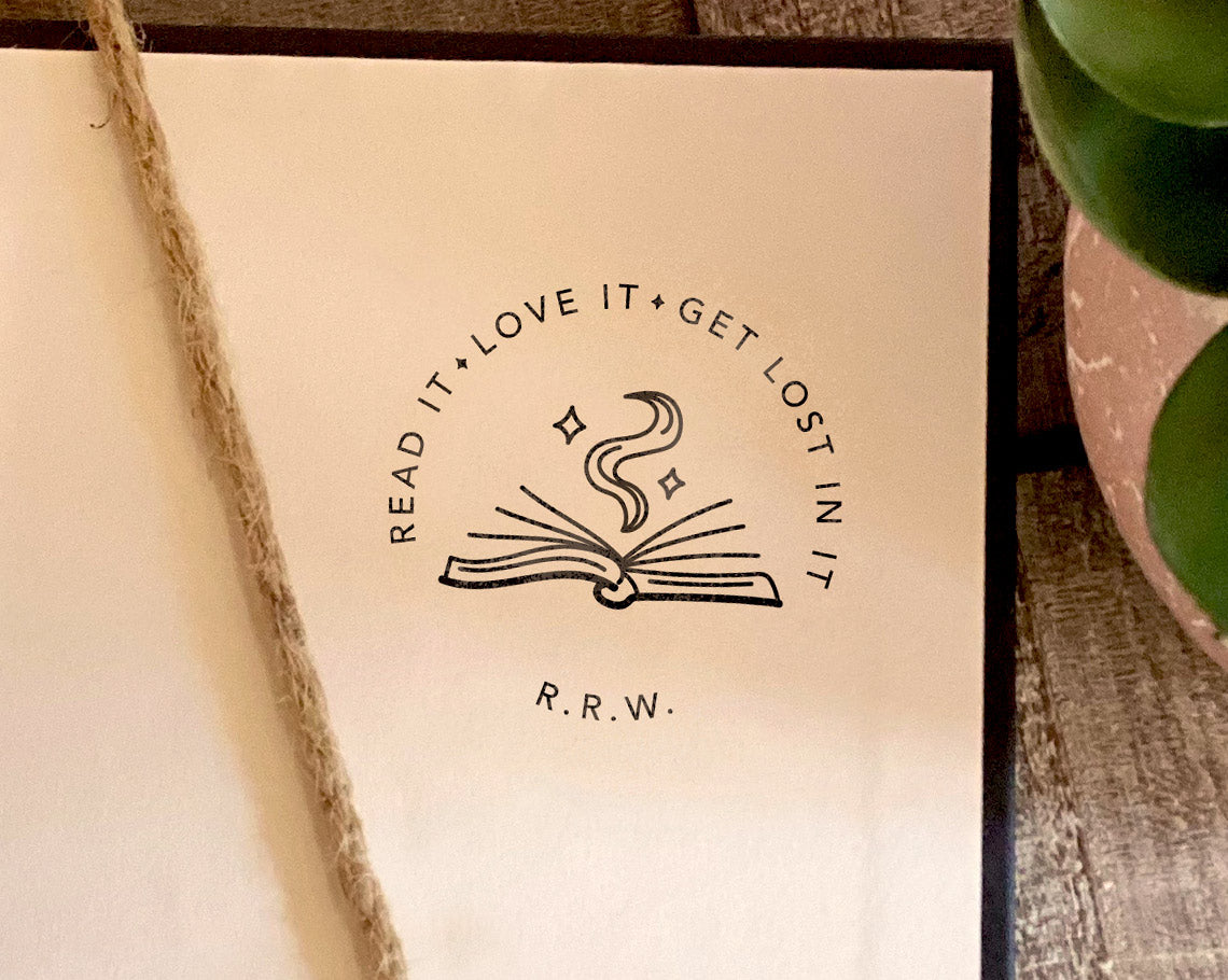 rubber book stamp with its mark on book page that says read it love it get lost in it with owners initials