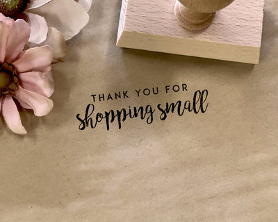 rectangular rubber stamp with its imprint on a parchment paper that says thank you for shopping small